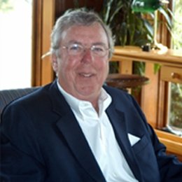 Person wearing glasses and suit smiling 