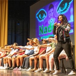 Students participating in event sitting in chairs on stage