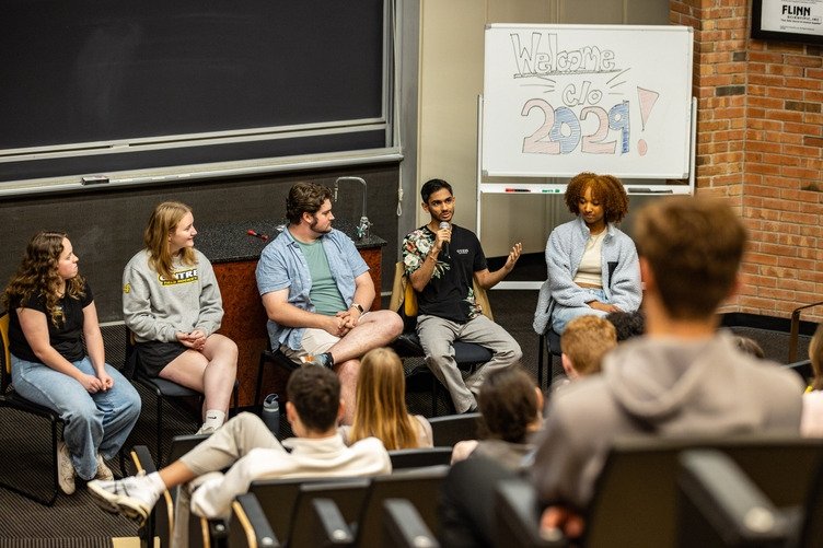A panel of 5 students speak to an audience of prospective families.
