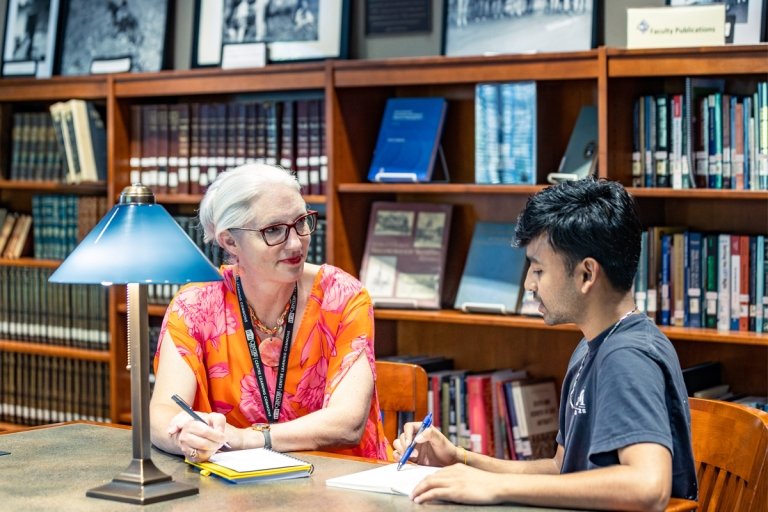 Karen Tubb mentoring a student in the library