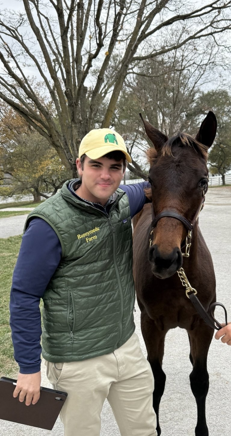 Centre College student Catesby Clay stands with his arm on the neck of a young horse he just purchased at auction. 