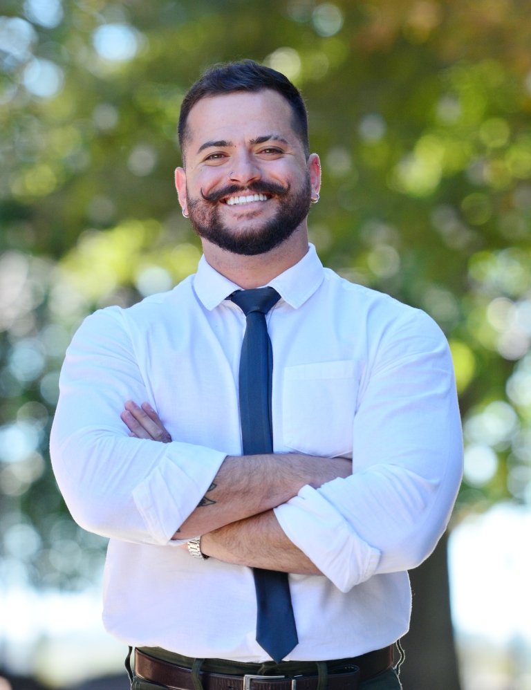 Matheus Marlisson smiles with his arms crossed while posing for a photo. 