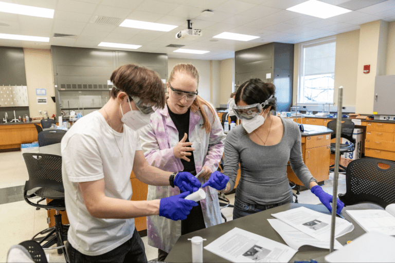 Reagan Witt helps students examine a substance during a lab.