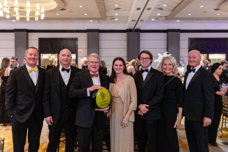 George Sanderlin holds his Associate of the Year award while surrounded by family and members of the Centre College staff&nbsp;