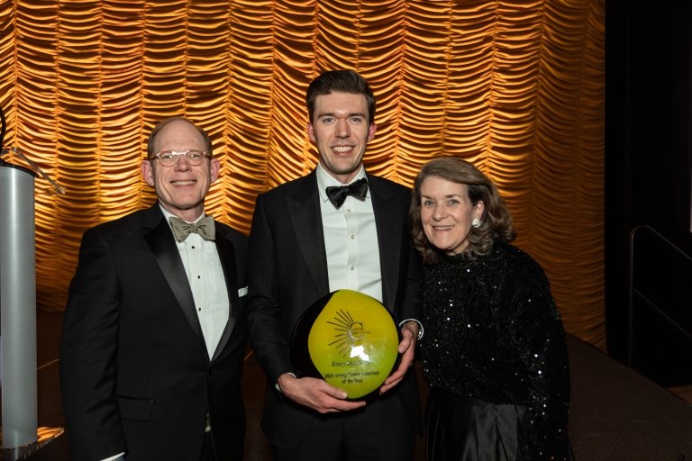 Henry Snyder holds his Associate of the Year award while flanked by his parents.