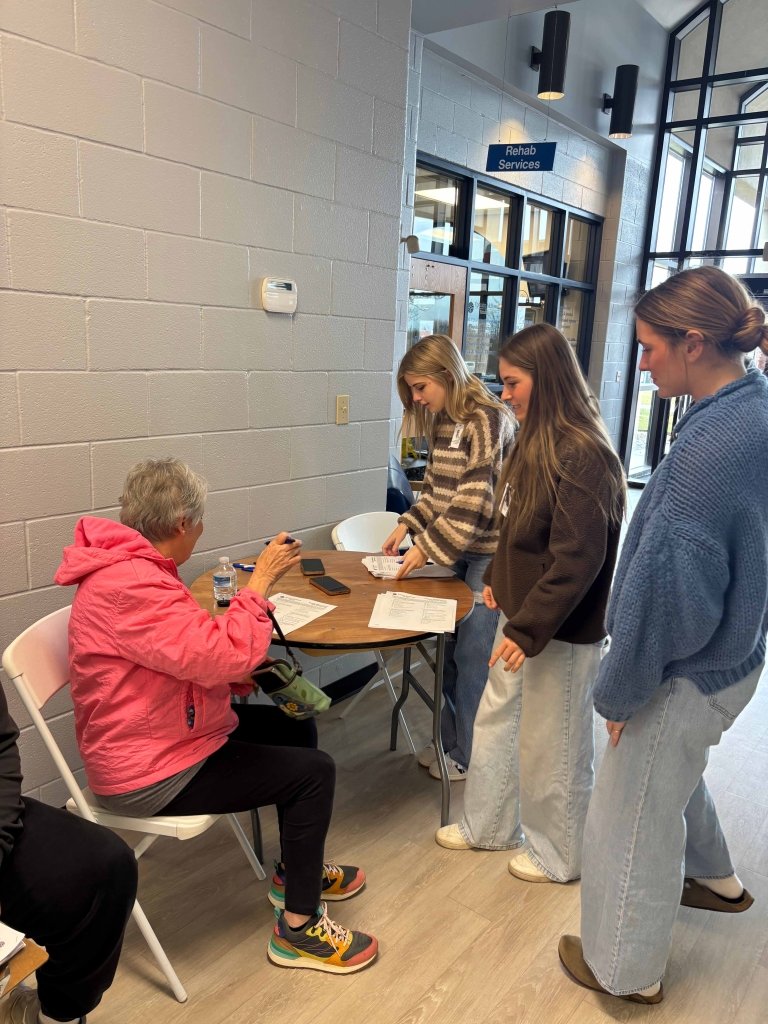 Centre students are surveying an older women.