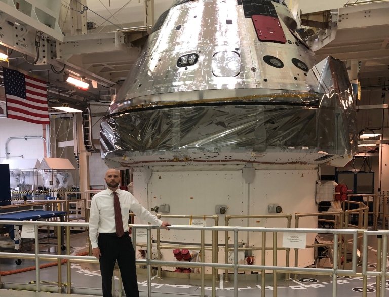 Jimmy Skaggs stands indoors in front of the Orion space capsule, which was sent into lunar orbit by the Artemis II rocket launch, 
