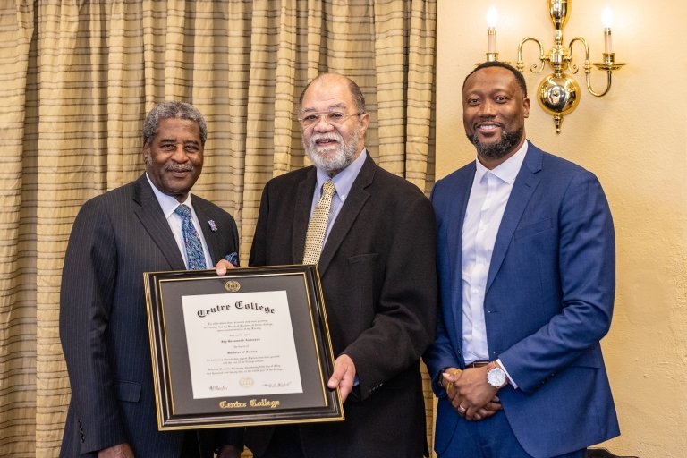 Raymond Burse, Jay Anderson and Athony Jones pose together with Anderson's framed Centre College degree.