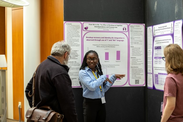 A young woman points to a research papers as she talks with a man and another young woman during the Centre College RICE Symposium.