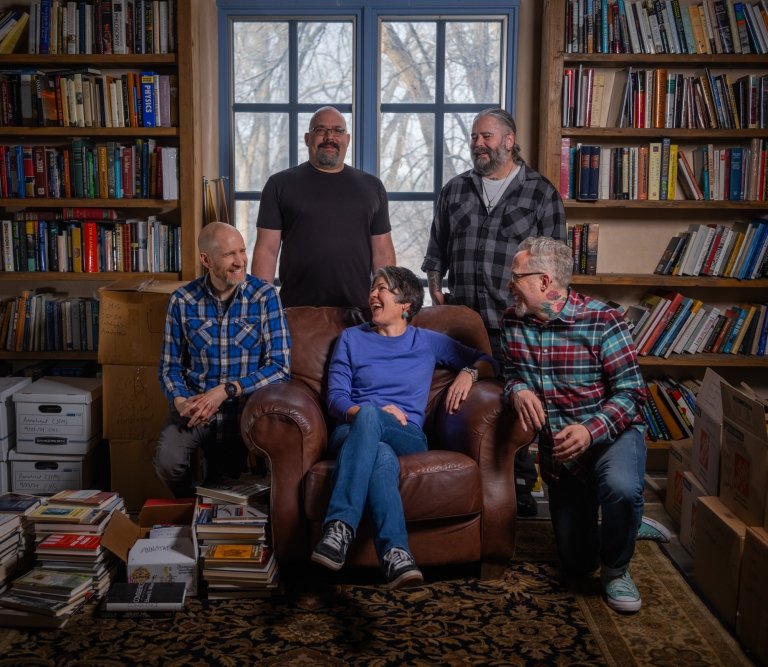 Five members of the Cormac McCarthy Society pose for a photo in the author's personal library. Seated at center in a leather armchair is Centre College English professor Stacey Peebles.
