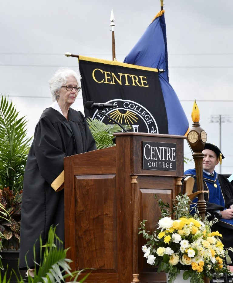 Crit Blackburn Luallen stands behind a Centre College podium wearing a black robe during Commencement. 