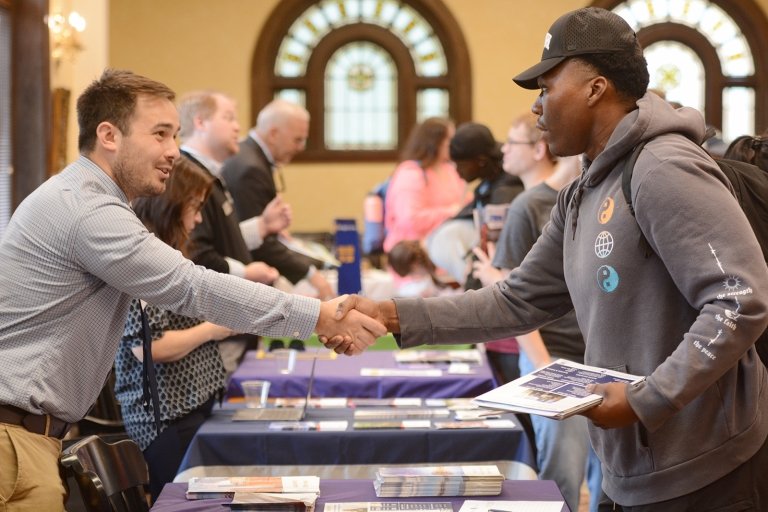 A Centre College student shakes hand with a law school recruiter at a graduate school fair on campus.