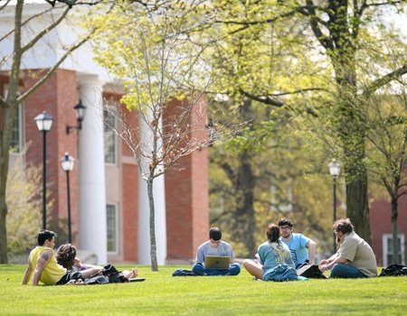 Group of students meeting with professor outside science building