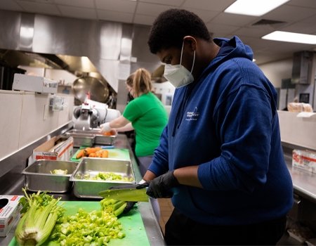 Student participating in meal prep for food bank