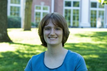 lady with short brown hair wearing blue top in front of student center