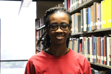 Allotey in library smiling at camera