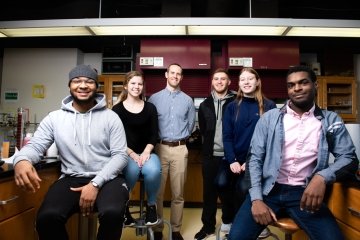 Daniel Scott pictured with students Micai Benford (front right), and Cole Hilt (middle right), both who worked the paper with Scott.