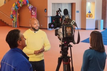 Artist in residence Devine Carama speaks to reporters during Building Bridges Day 2023 at the Norton Center for the Arts.