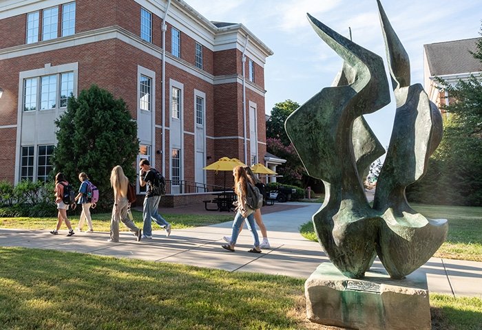 Students walking to class near the flame sculpture