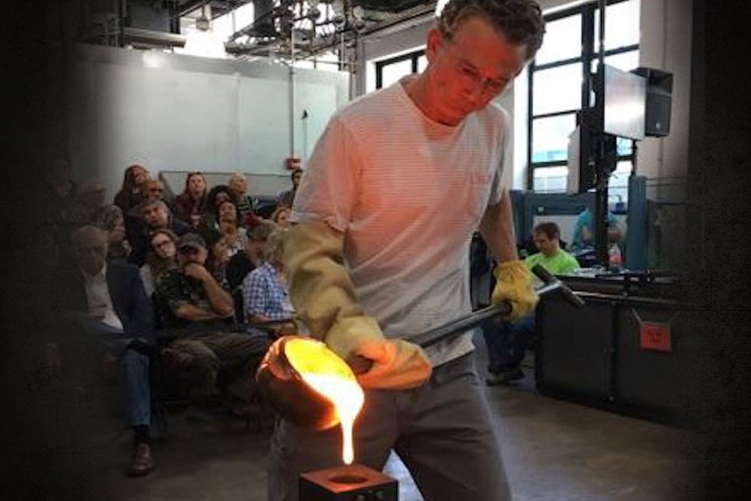 Martin pouring hot glass into a mold in front of an audience