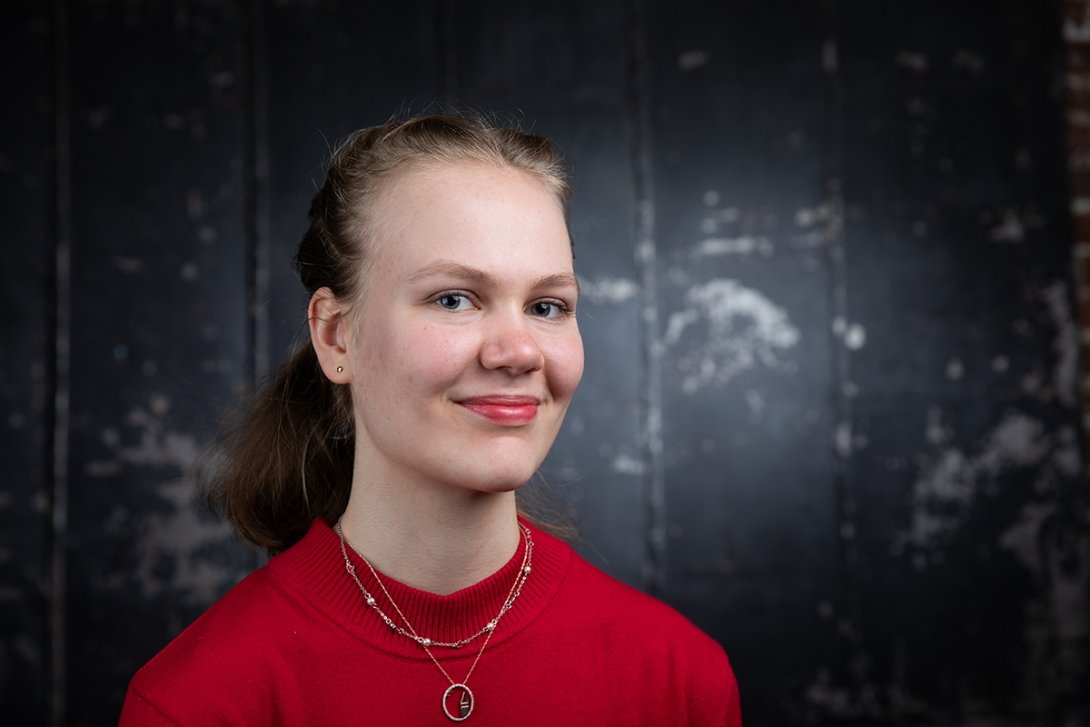 headshot of Uliana wearing red sweater and smiling at camera
