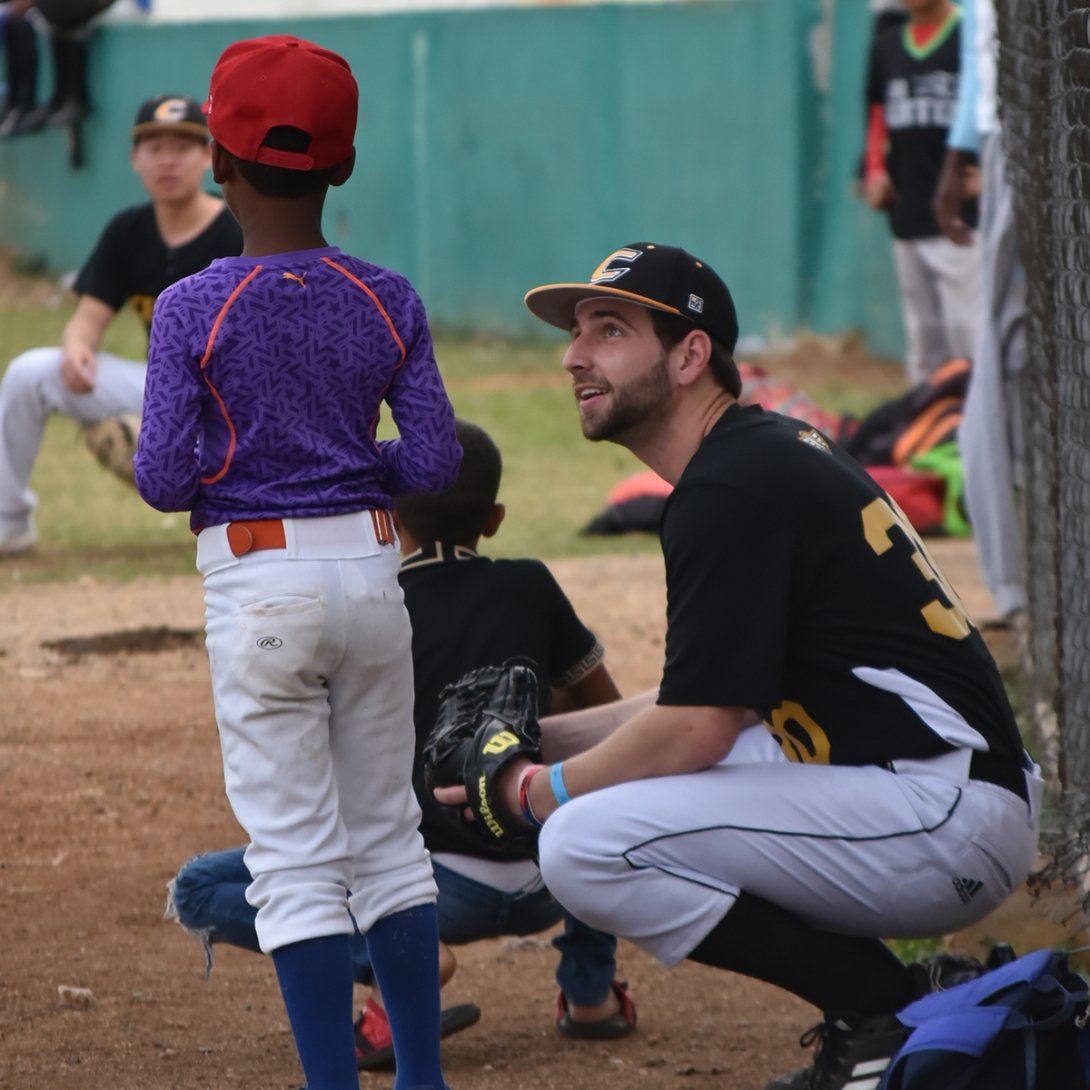 Will Kempf, class of 2024, talks with a young baseball player in the Dominican Republic.