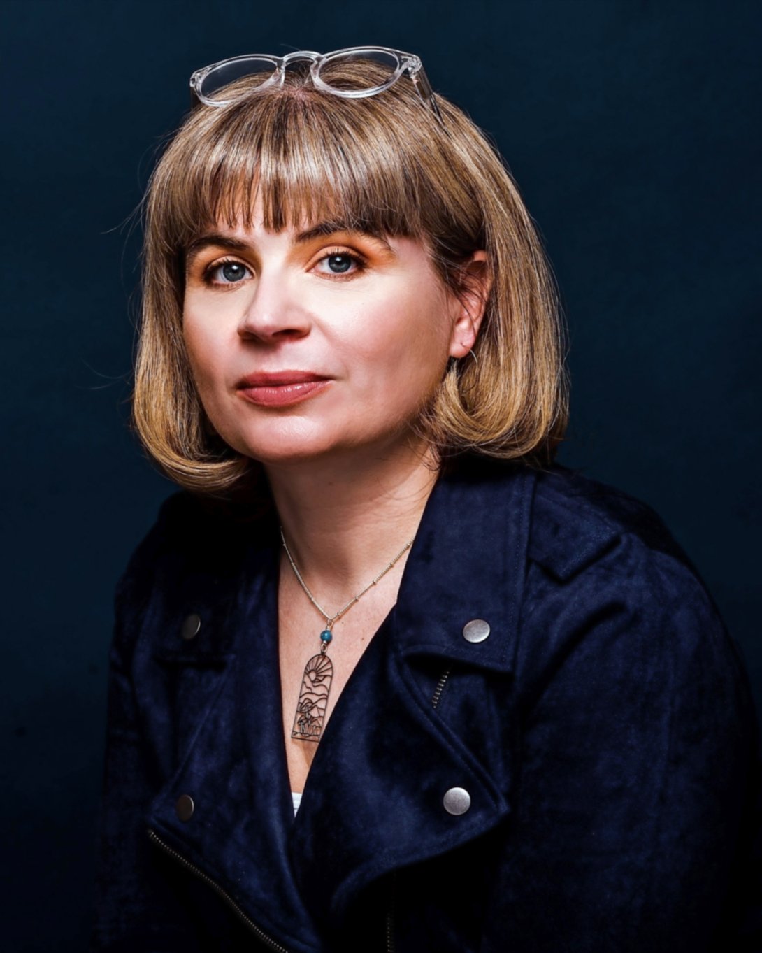 A woman with short blond hair poses for a photo.