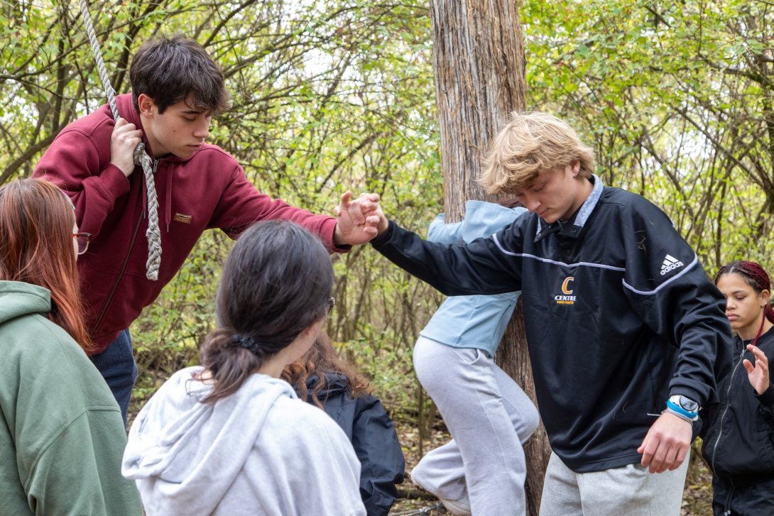Two Kessler Scholars help each other through a ropes course.