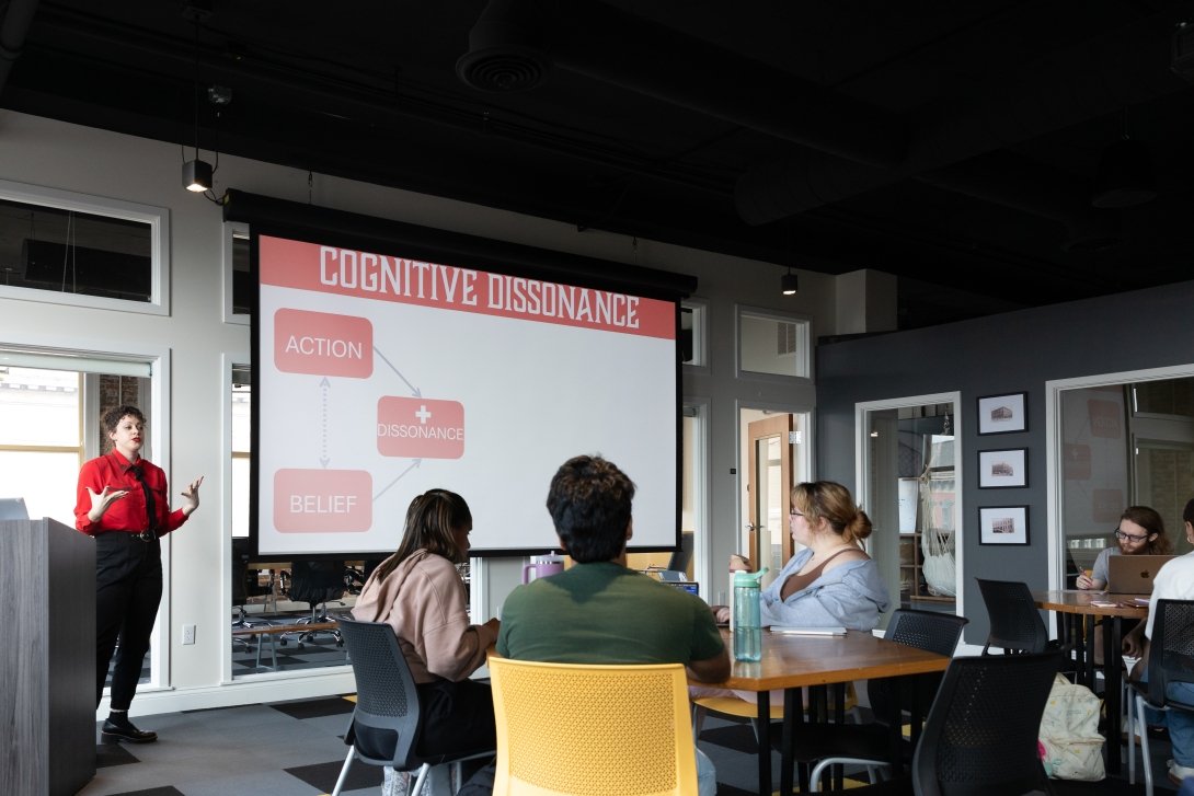Morgan Cope is presenting to a group of students about Cognative Dissonance. The class is taking place in CentreWorks.